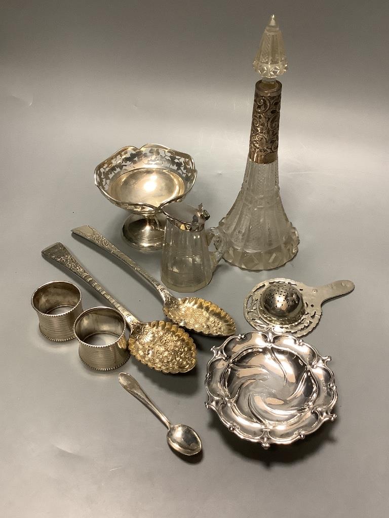 A mixed group of silver including a pair of George III silver Berry spoons, a pair of silver napkin rings, silver nut dish, white metal tea strainer a silver mounted whisky tot jug, 800 spoon, small silver pedestal bowl